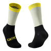 A pair of cycling socks featuring a white body and yellow cuff, with black ankle sections.