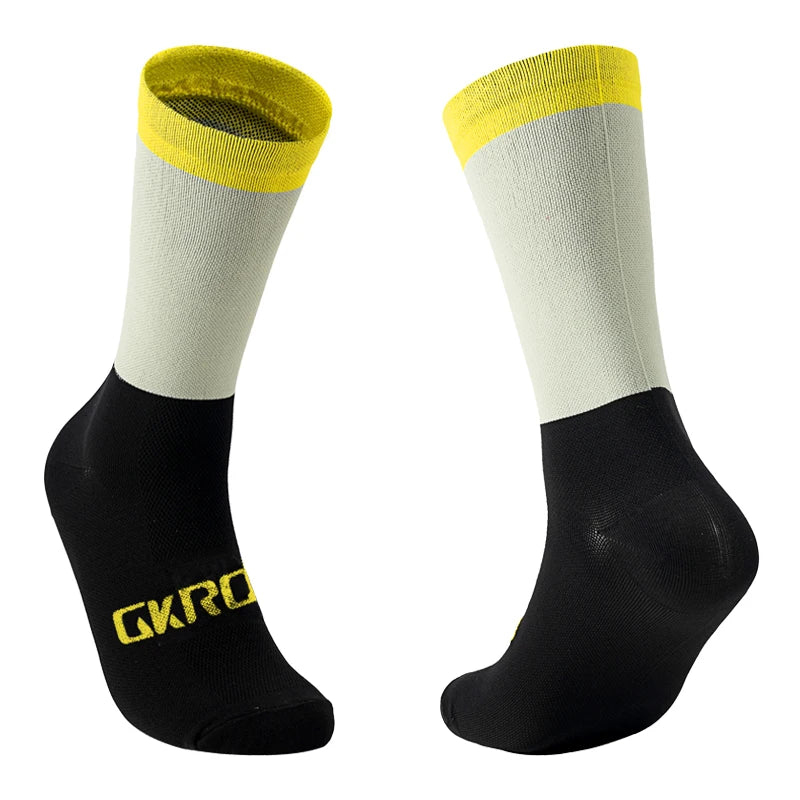 A pair of cycling socks featuring a white body and yellow cuff, with black ankle sections.