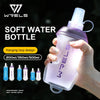 A hand holds a purple soft water bottle with a hanging loop design, showcasing various sizes.