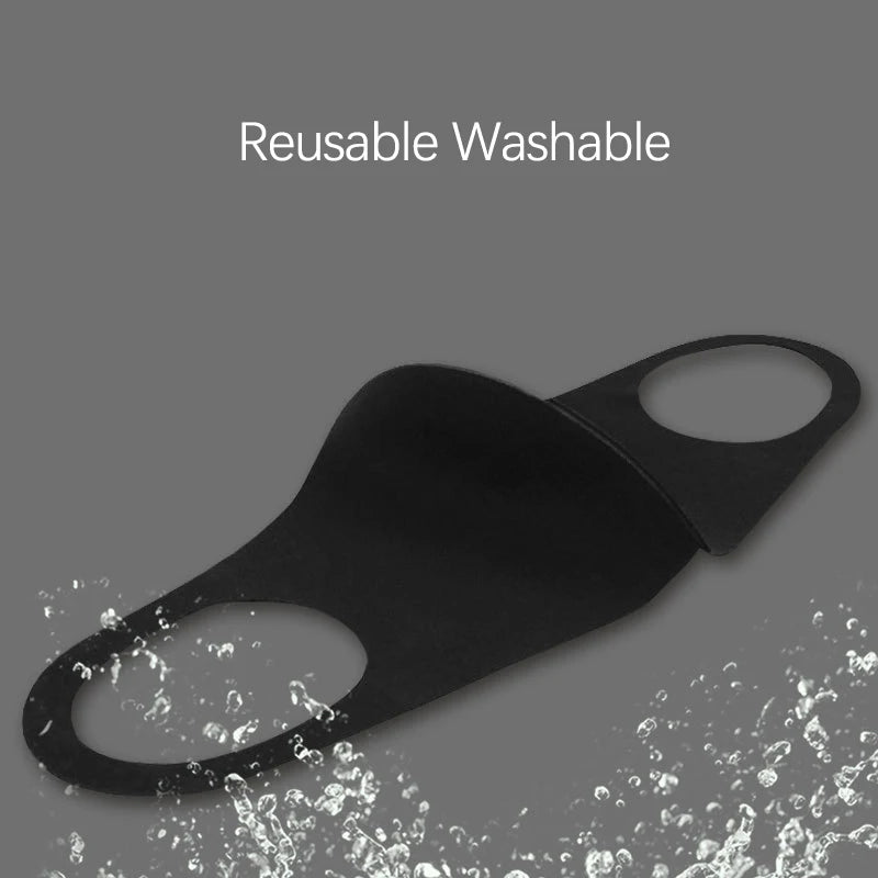Black reusable washable face mask being washed with water.