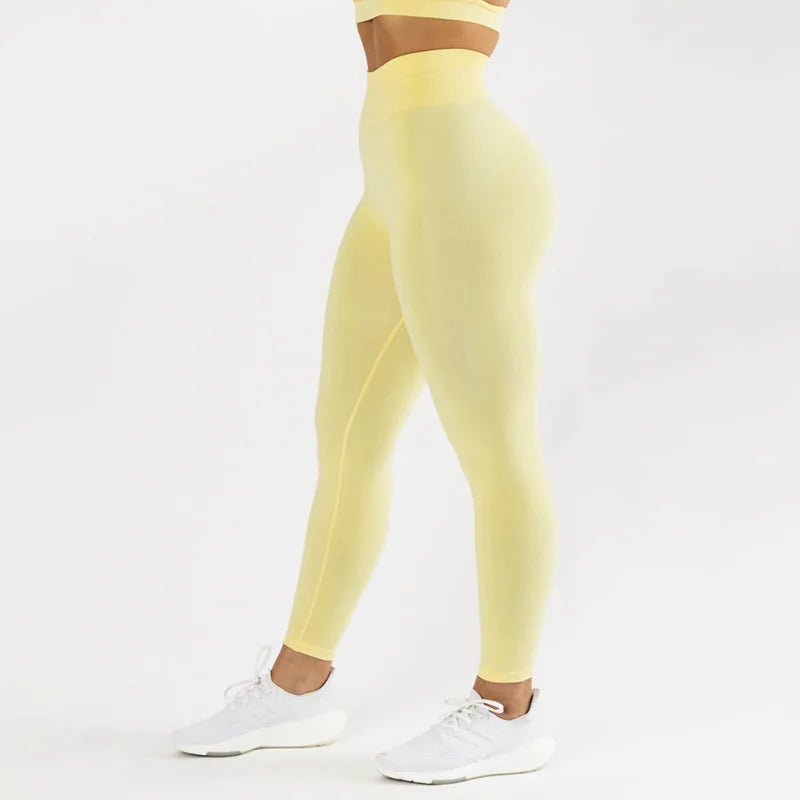 Une personne portant un legging de yoga sans couture taille haute jaune et un soutien-gorge de sport assorti.