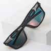 A pair of black polarized sports sunglasses with a silver frame resting on a white surface.