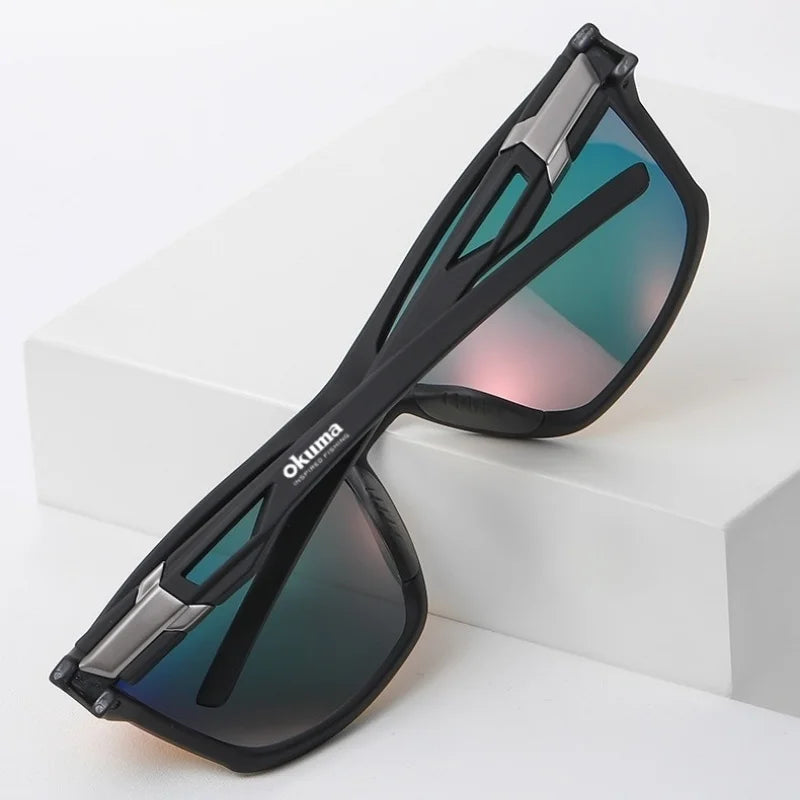 A pair of black polarized sports sunglasses with a silver frame resting on a white surface.