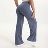 A person wearing dark blue NCLAGEN SoftMotion straight leg yoga pants and a light top standing.