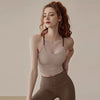 A woman wearing a beige supportive sports bra and matching leggings posing for a photo.