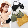 A collection of women's cross strap sports bras in black, olive green, white, and yellow.