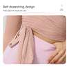 A close-up of a pink breathable top being tied into a belt drawstring design on a woman's torso.