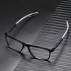 A pair of black vintage square reading glasses with silver arms resting on a dark, textured surface.