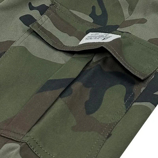 Close-up of olive green and brown camouflage fabric on men's cargo pants.