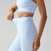 Un mannequin portant des leggings de performance bleu clair à taille haute.