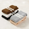 A stack of women's striped cotton knee high socks in brown, white, and black colors.