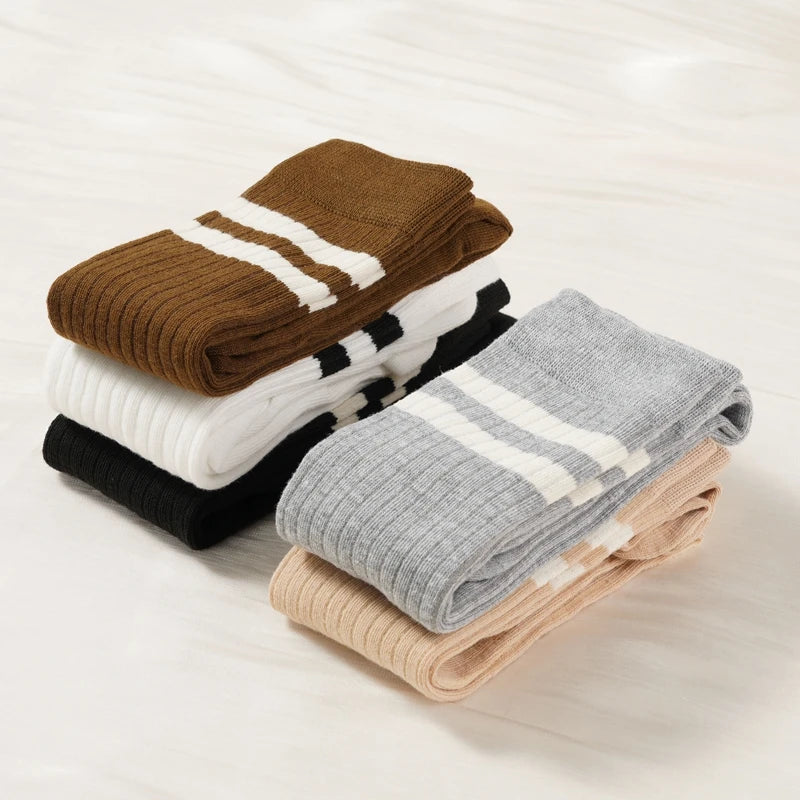 A stack of women's striped cotton knee high socks in brown, white, and black colors.