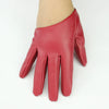 A close-up of a reddish-pink PU leather finger glove worn on a hand.