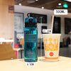 A clear blue sports water bottle with a tea infuser is shown next to a cup of iced coffee.