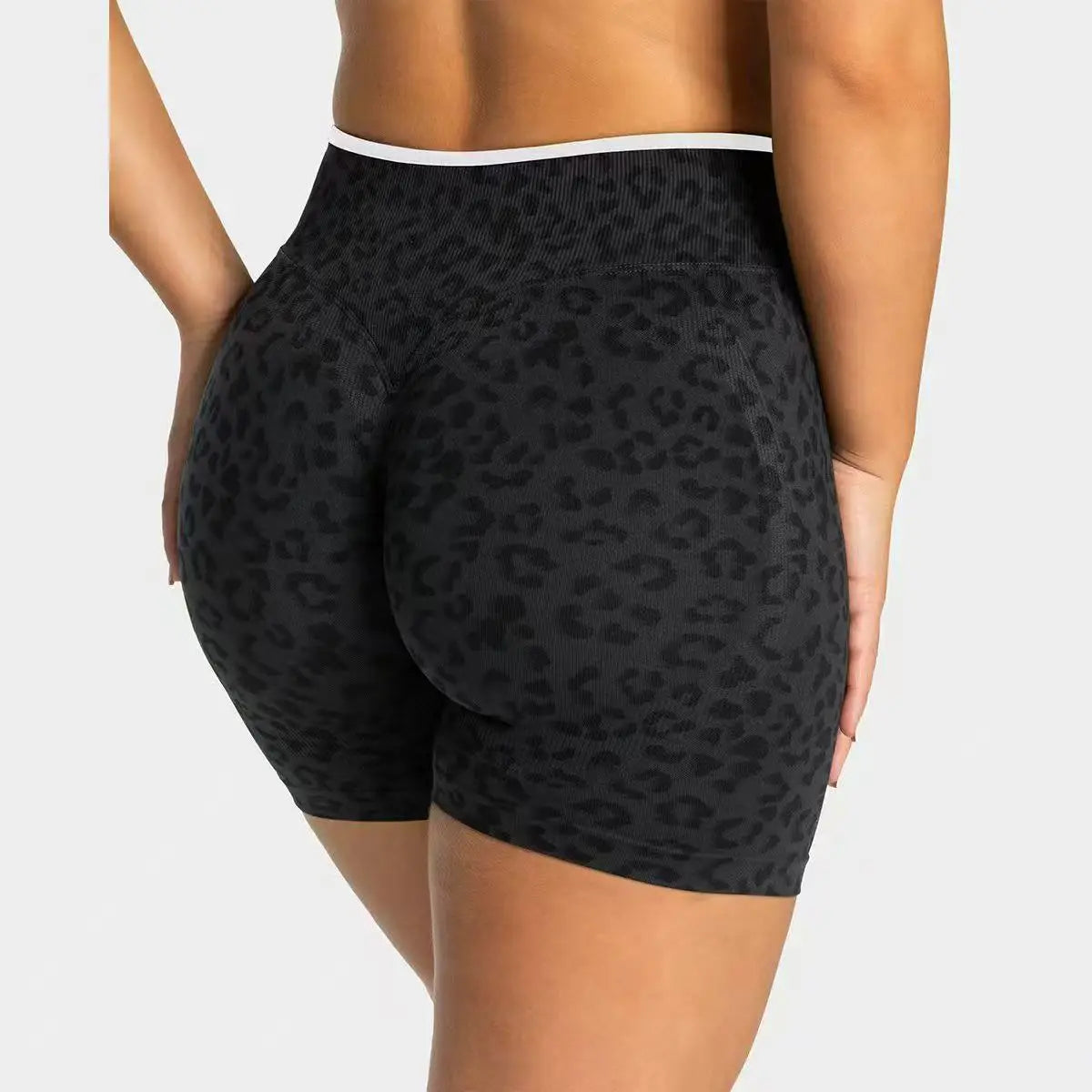 Black leopard print seamless yoga shorts worn by a person.