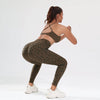 A woman models a leopard print seamless two-piece sports set in olive green against a white background.