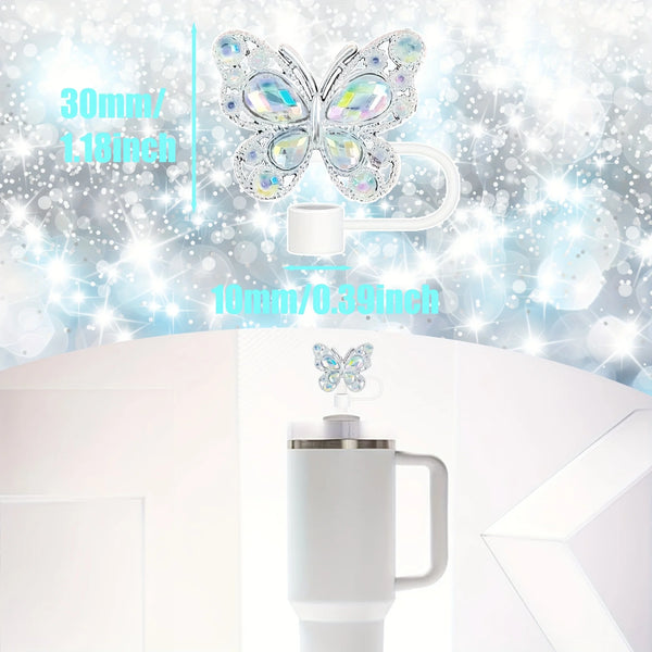 A set of silicone butterfly straw toppers with a clear plastic butterfly and a white straw topper shown on a white mug.