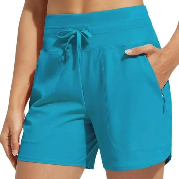 A close-up of a woman wearing bright turquoise high-waisted quick-dry athletic shorts.