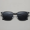 Black sunglasses with a metal frame displayed against a light gray background.