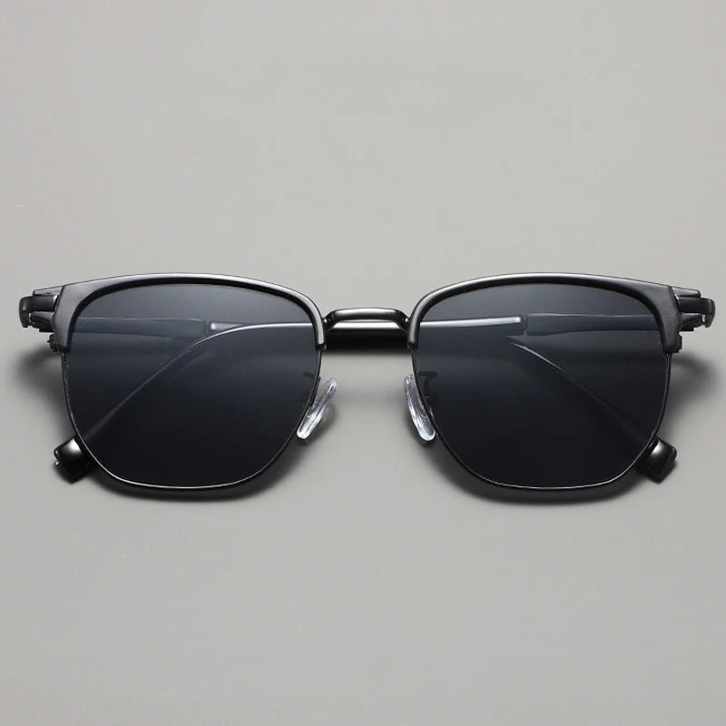 Black sunglasses with a metal frame displayed against a light gray background.