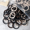 A pile of 50 mixed color elastic hair bands in black, brown, and beige are displayed on a light surface.