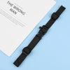 A black adjustable tactical backpack strap harness lying on a light blue surface next to a document.