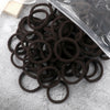 A pile of dark brown elastic hair bands is shown next to a clear plastic sheet.