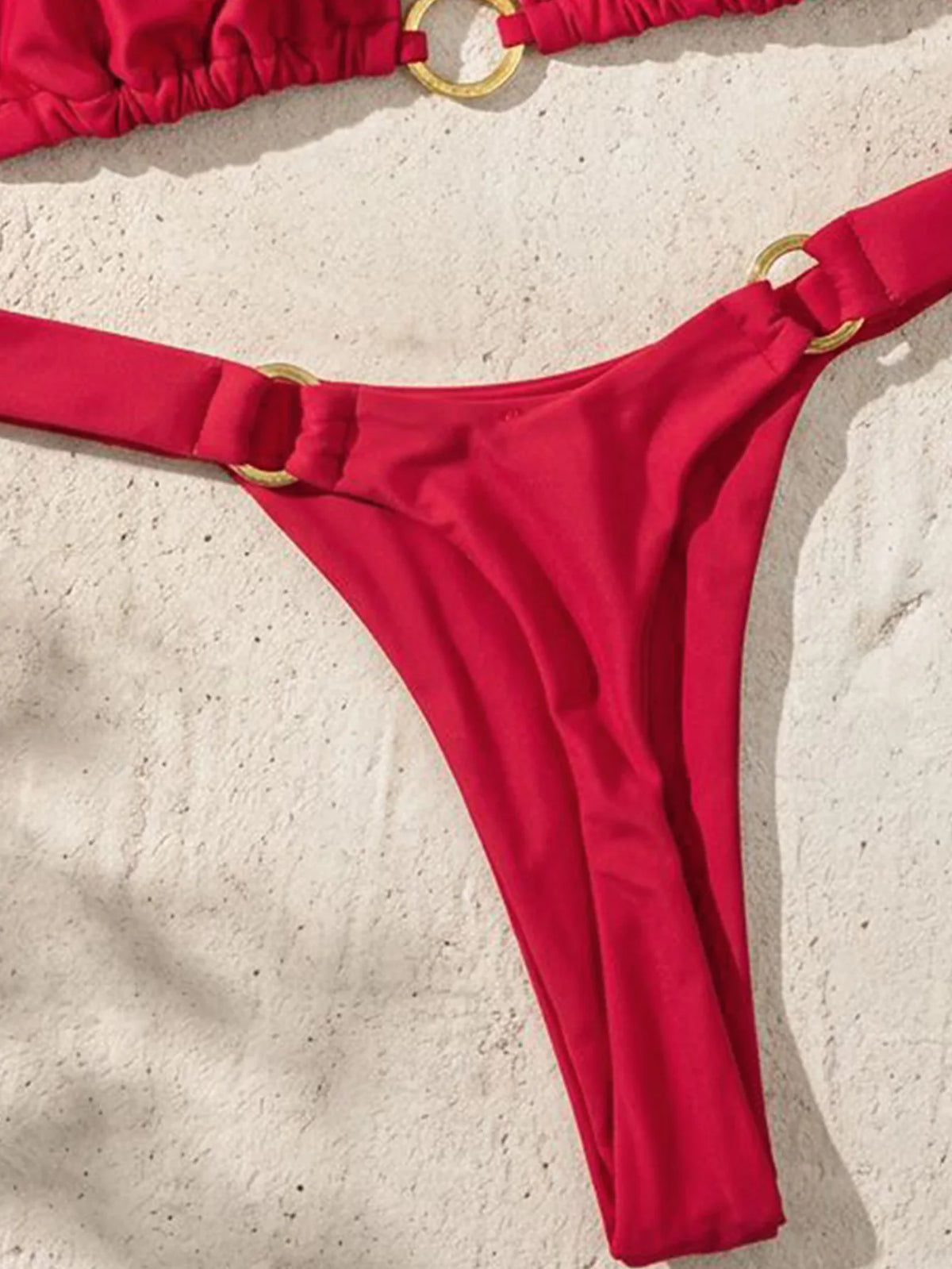 A bright red tie-side low rise bikini bottom is shown against a light background.