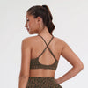 A woman models a leopard print seamless two-piece sports set, showing the back view.