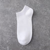 A white ankle sock is shown against a gray textured background.