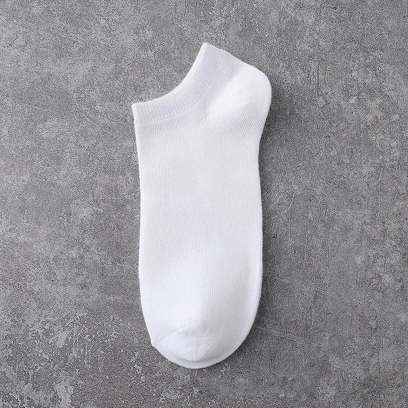 A white ankle sock is shown against a gray textured background.