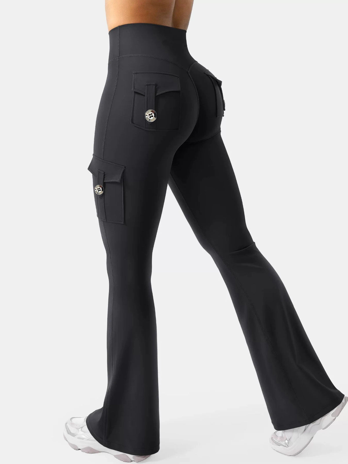 A model is wearing high-waisted black flared fitness pants with functional pockets.