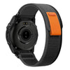 A black Garmin sports watch with an orange nylon strap shown from the side.