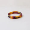 A yellow and orange silicone wristband with the number 23 printed on it.