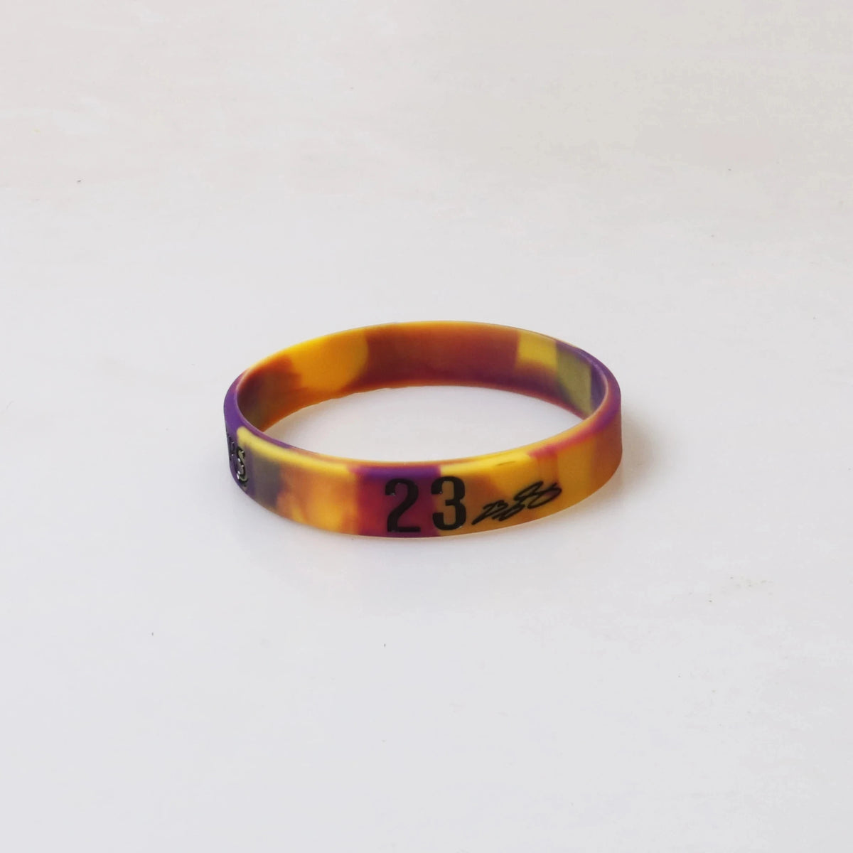A yellow and orange silicone wristband with the number 23 printed on it.