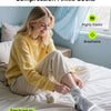 A woman wearing compression ankle socks is sitting on a bed, demonstrating the easy fit of the socks.