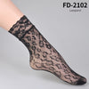 Schwarze Leopardenmuster-Lace-Strümpfe an einem Fuß eines Models.