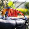 A pair of orange-tinted polarized sports sunglasses resting on a bicycle handlebar.
