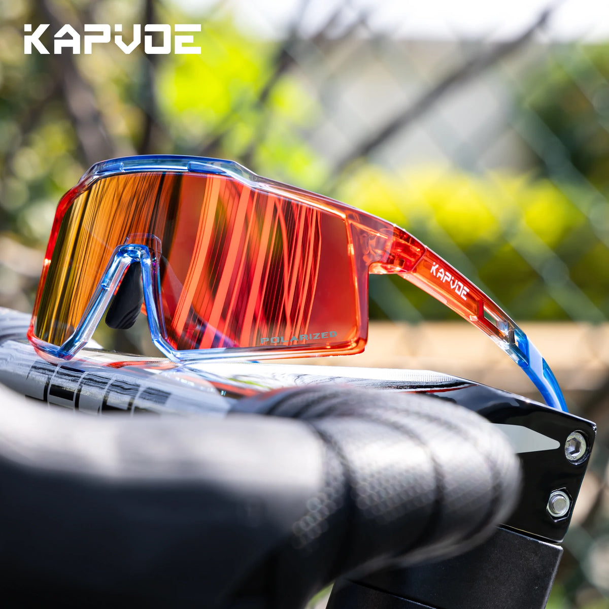 A pair of orange-tinted polarized sports sunglasses resting on a bicycle handlebar.