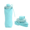 A light blue silicone folding water bottle with a cap and a folded light blue cloth in the background.