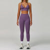 Eine Frau modelliert ein nahtloses Sport-Yoga-Set in Lila mit Crop-Top und langen Leggings.