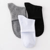 A set of three men's mid-calf cotton socks in gray, black, and white.