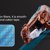 A woman applying blue kinesiology tape to her arm while exercising.