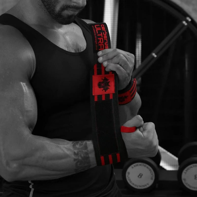 Une personne porte un débardeur noir et tient des bandes de poignet pour musculation rouges et noires.