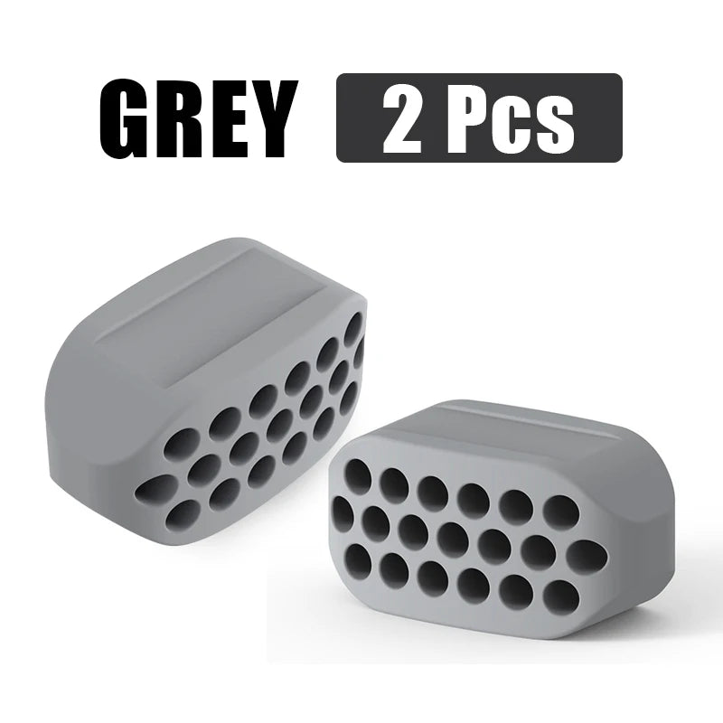 Two grey silicone jawline exercisers for facial toning.
