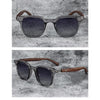 A pair of trendy sunglasses with dark gray frames and brown wood grain arms resting on a textured surface.