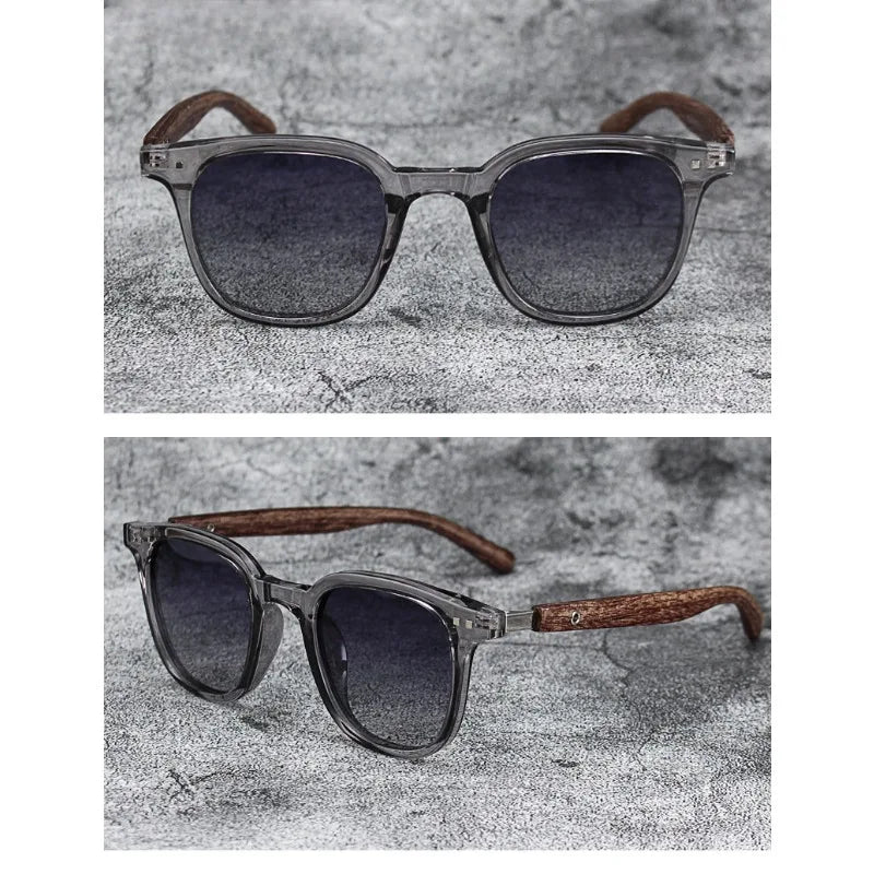 A pair of trendy sunglasses with dark gray frames and brown wood grain arms resting on a textured surface.