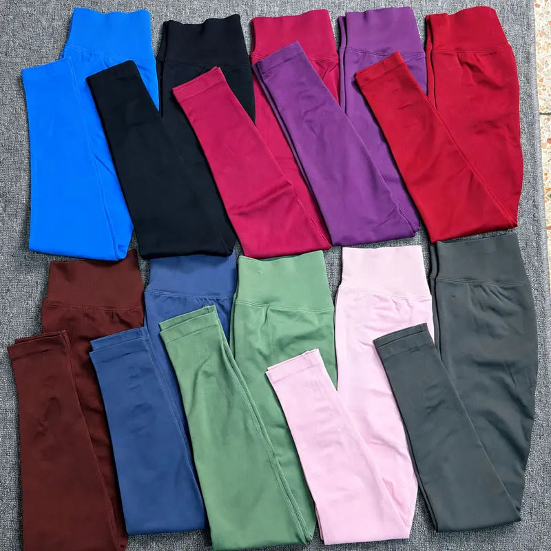 Eine Kollektion von hochtaillierten, nahtlosen Yoga-Leggings in verschiedenen einfarbigen Farben wie Blau, Schwarz, Magenta, 