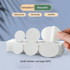 A hand holds several white self-adhesive shoe repair patches in small, medium, and large sizes.