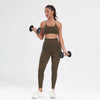 A woman wearing a leopard print seamless two-piece sports set, consisting of a crop top and leggings, holding dumbbells.